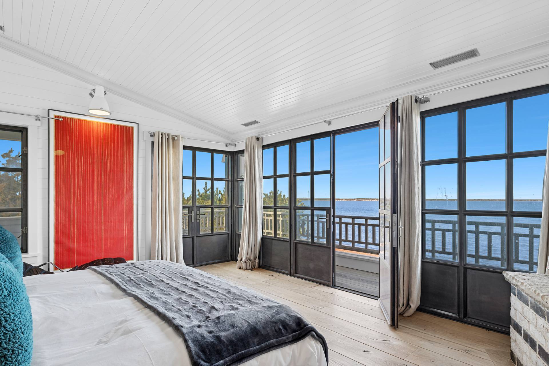 30 Private Road Amagansett, NY 11930 - Photo 16 of 26 a bedroom with a balcony a bed and a dresser next to a window