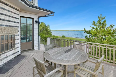 a view of a balcony with table and chairs and wooden floor