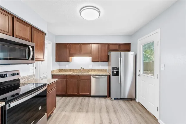 a kitchen with stainless steel appliances granite countertop a refrigerator stove and sink