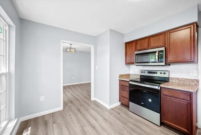 a kitchen with wooden floors and stainless steel appliances