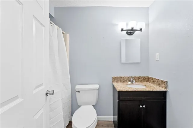 a bathroom with a sink and mirror with toilet