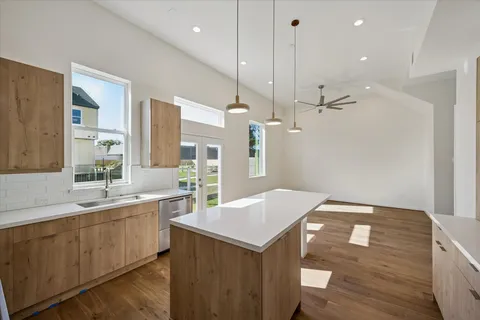 a kitchen with a sink a counter space and wooden floor