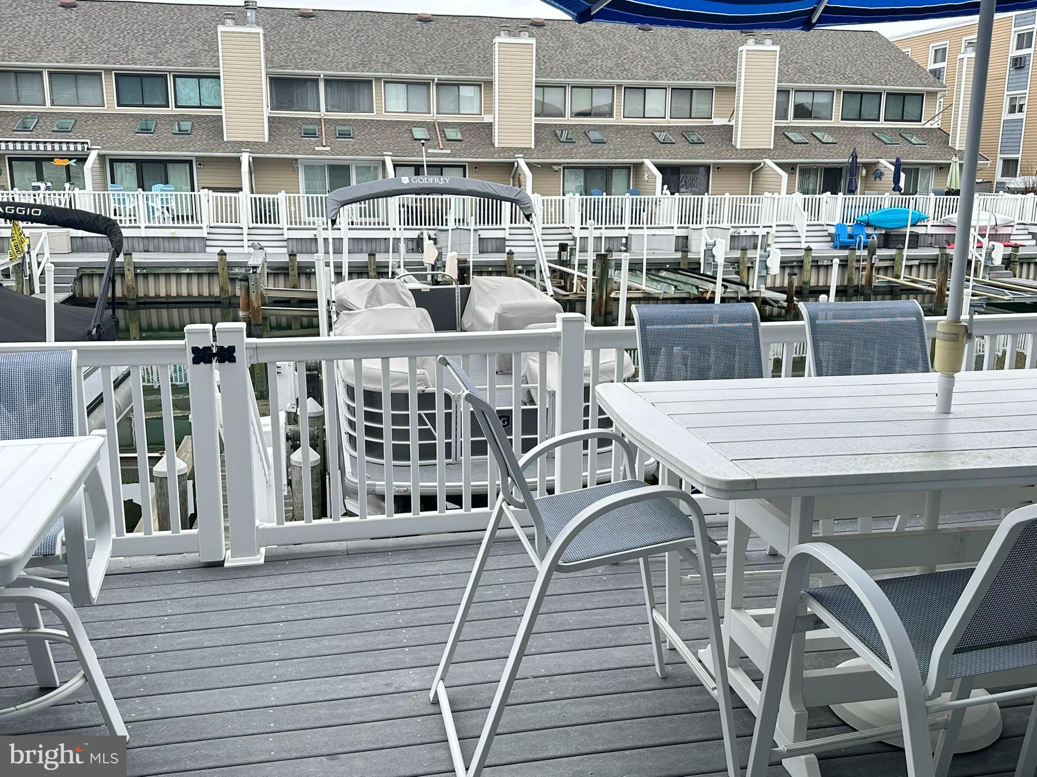 712 Mooring Road Ocean City, MD 21842 - Photo 14 of 60 a view of a rooftop deck with dining table and chairs