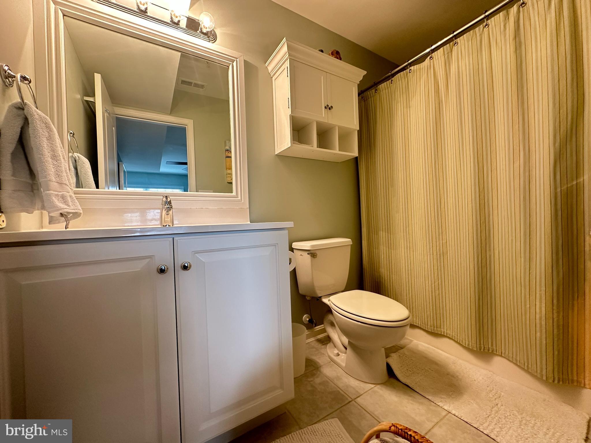 712 Mooring Road Ocean City, MD 21842 - Photo 33 of 60 a bathroom with a sink a toilet a mirror and shower curtain