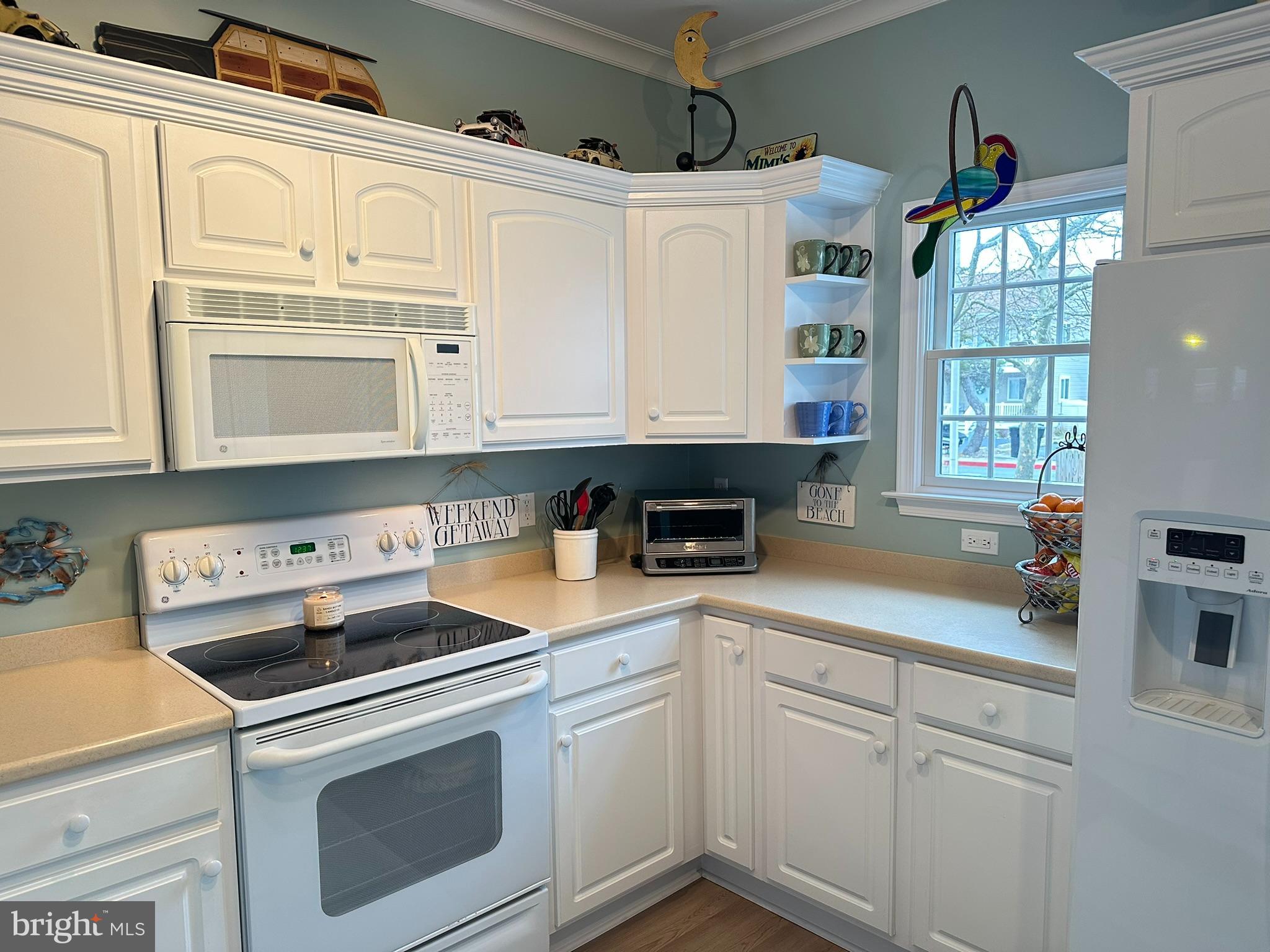 712 Mooring Road Ocean City, MD 21842 - Photo 6 of 60 a kitchen with granite countertop white cabinets and white appliances