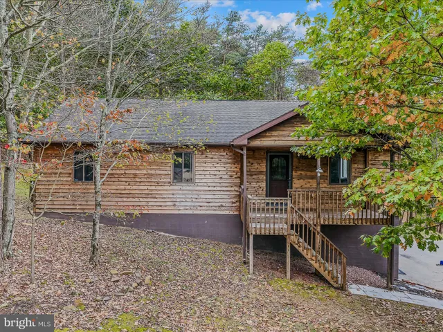 a view of a house with a yard and wooden deck