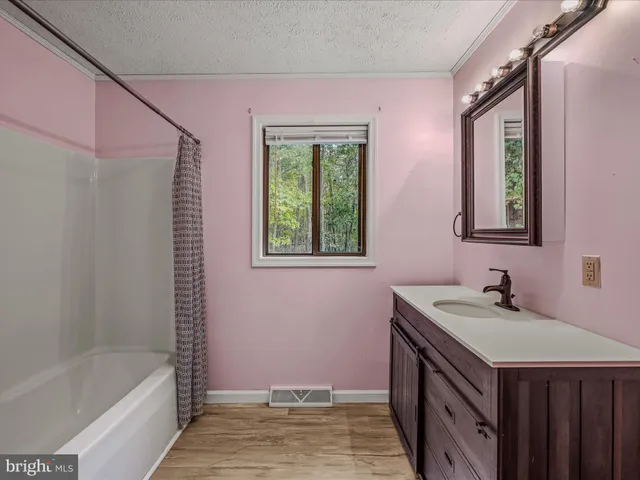 a bathroom with a tub sink and mirror