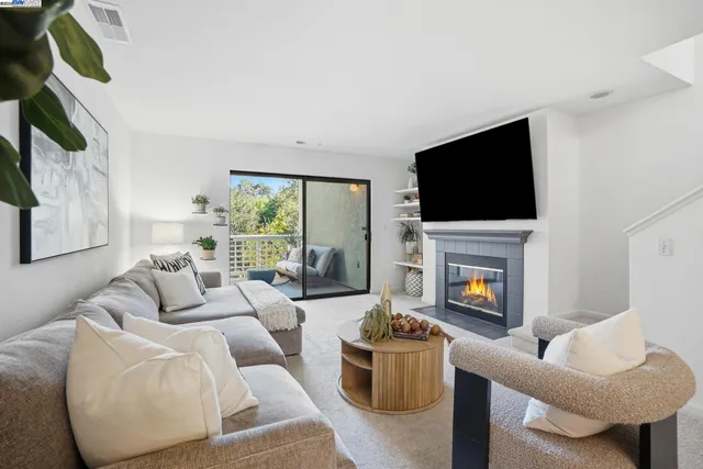 a living room with furniture a fireplace and a flat screen tv
