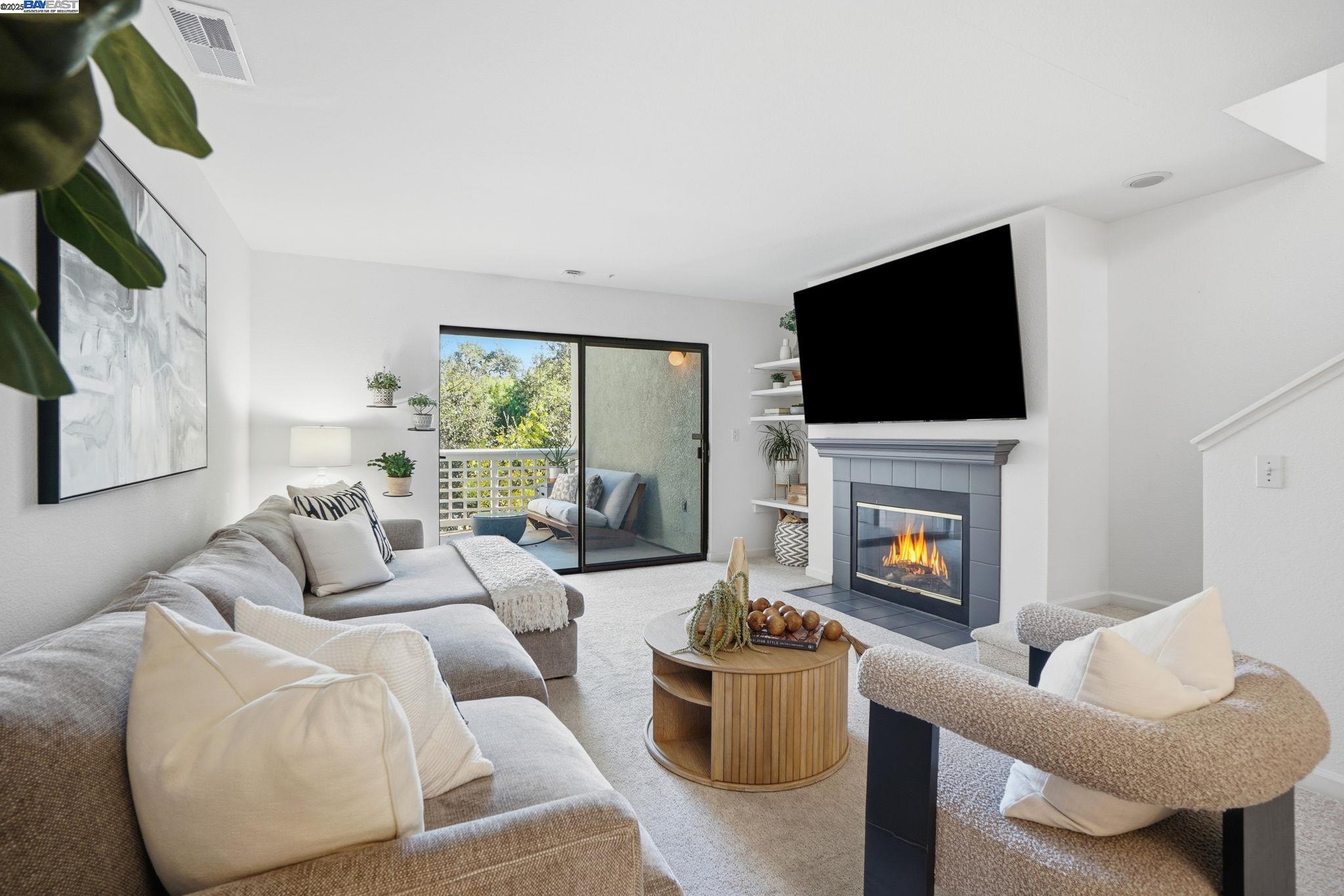 2586 Oak Road, Unit 229 Walnut Creek, CA 94597 - Photo 7 of 39 a living room with furniture a flat screen tv and a fireplace