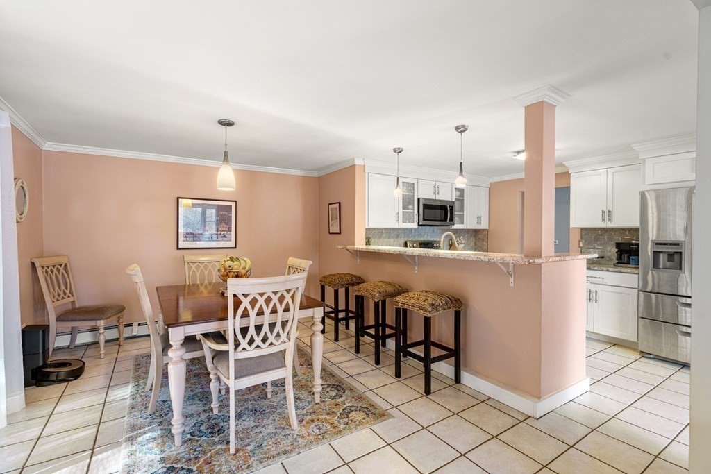 238 West Acton Road Stow, MA 01775 - Photo 10 of 37 a kitchen with stainless steel appliances kitchen island granite countertop a table chairs and a refrigerator