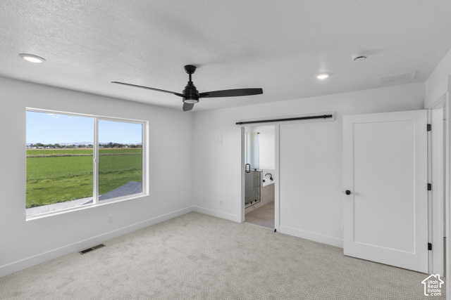 537 South 1150 West Logan, UT 84321 - Photo 21 of 33 Recessed lighting, ceiling fan, sliding barn door, paneled interior door, and a large window with a landscape view