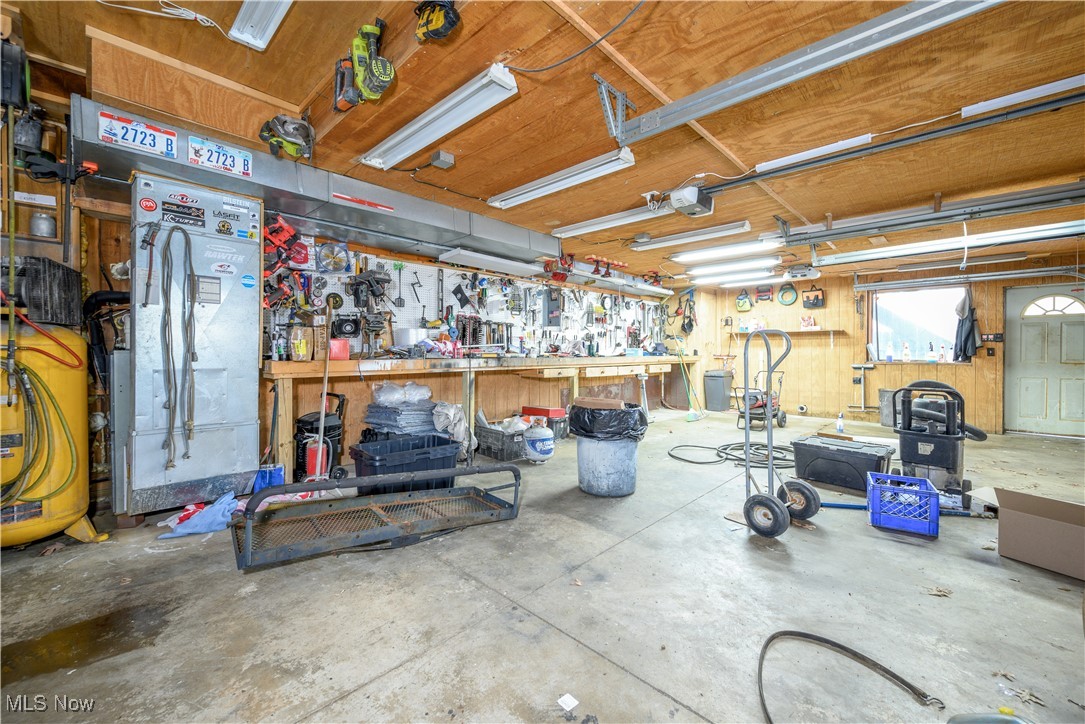 8731 Whipporwill Road Ravenna, OH 44266 - Photo 41 of 45 Garage with a garage door opener and a workshop area