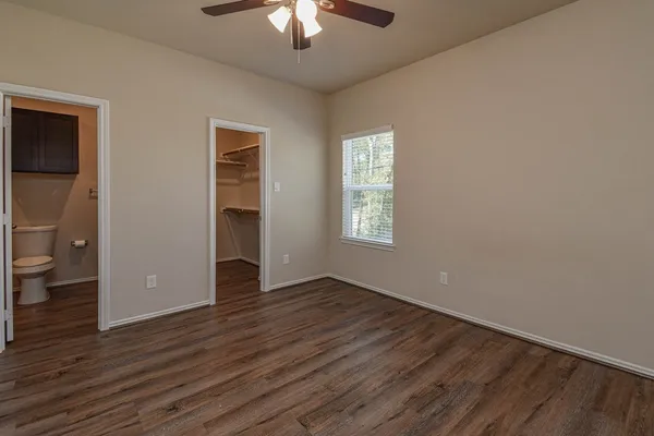 an empty room with wooden floor and windows
