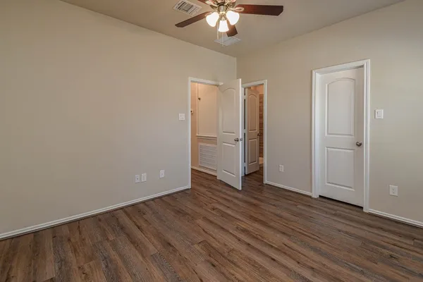 a view of an empty room with wooden floor