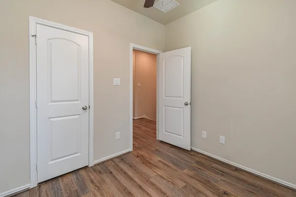 an empty room with wooden floor and closet