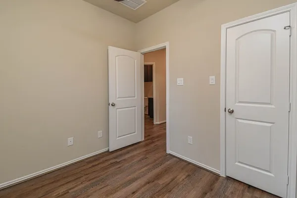 an empty room with wooden floor and closet