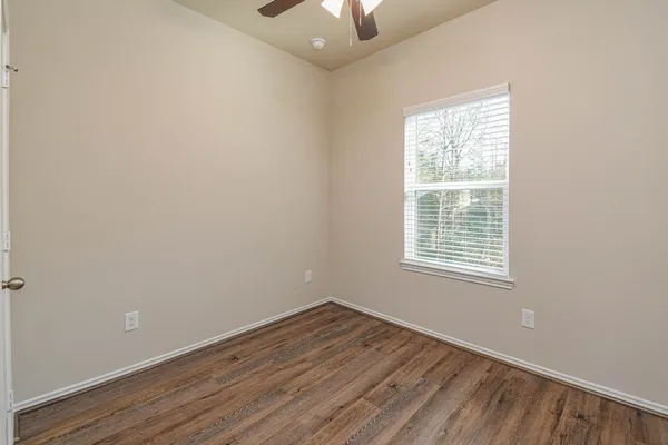 an empty room with a window and wooden floor