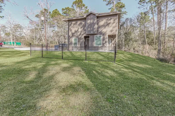 a view of a house with a big yard and large trees