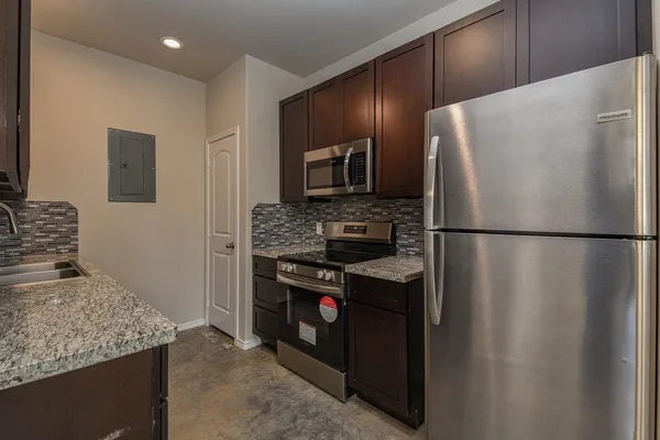 a kitchen with stainless steel appliances granite countertop a refrigerator and a stove