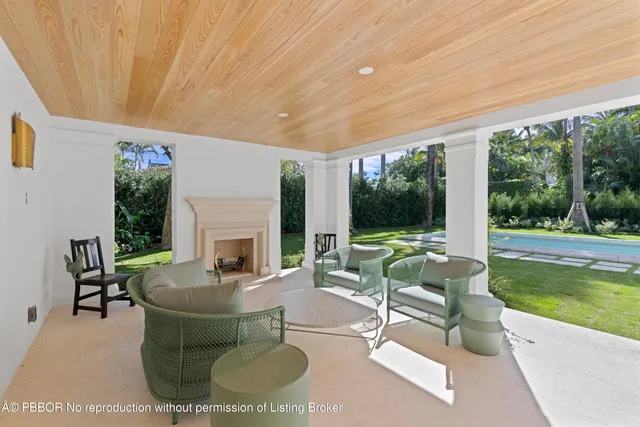 a living room with fireplace furniture and a large window