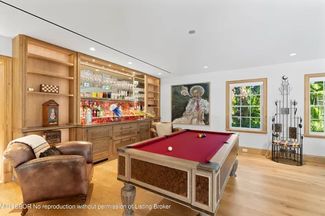 a room with pool table and windows