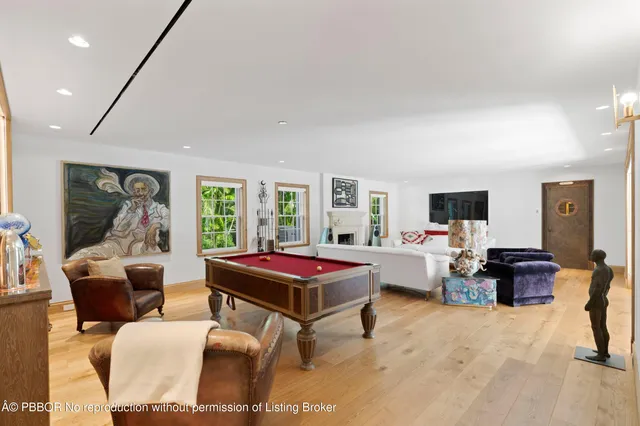 a living room with furniture flat screen tv and a large window