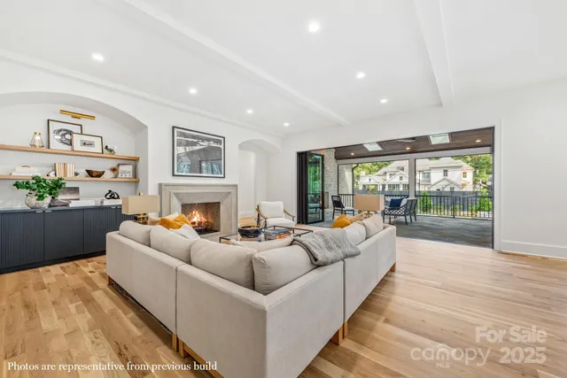 a living room with furniture large window and a fireplace