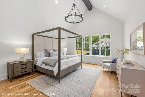 a bedroom with a large bed and a chandelier