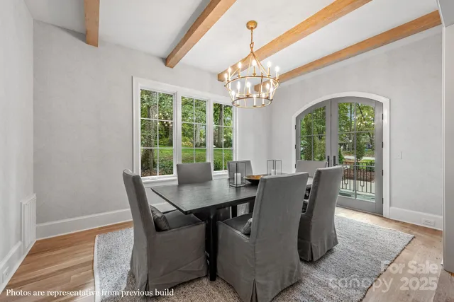 a view of a dining room with furniture a chandelier and wooden floor