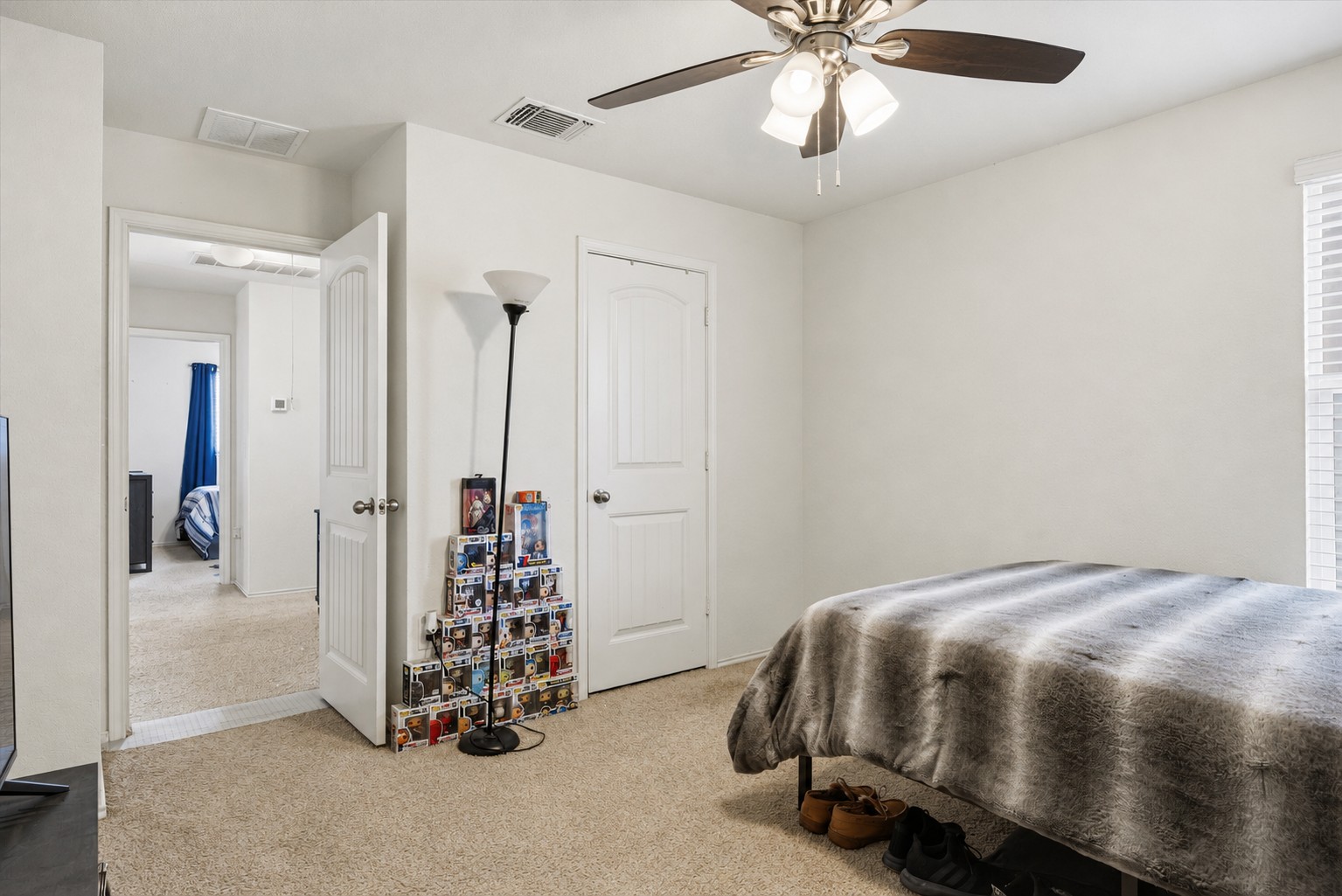 14904 Shalestone Way Manor, TX 78653 - Photo 25 of 32 a bedroom with a bed and a chandelier