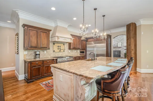 a dining room with wooden floor a chandelier a glass table and chairs