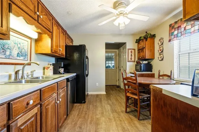 a kitchen with stainless steel appliances a sink cabinets and wooden floor