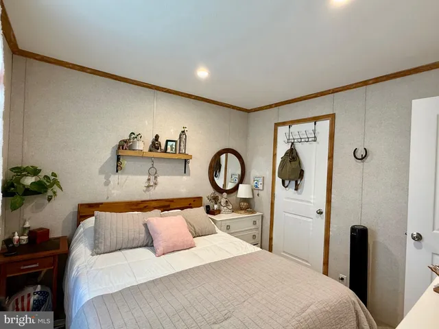 a bedroom with a bed and a potted plant on dresser