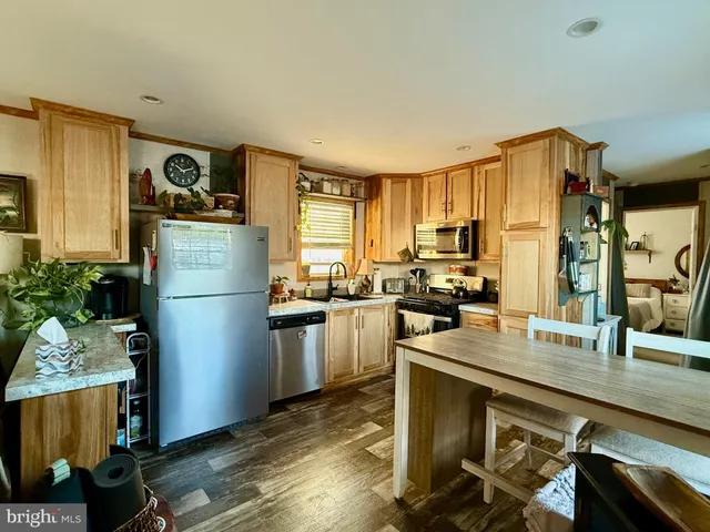 a kitchen with a refrigerator a sink dishwasher with a dining table and chairs