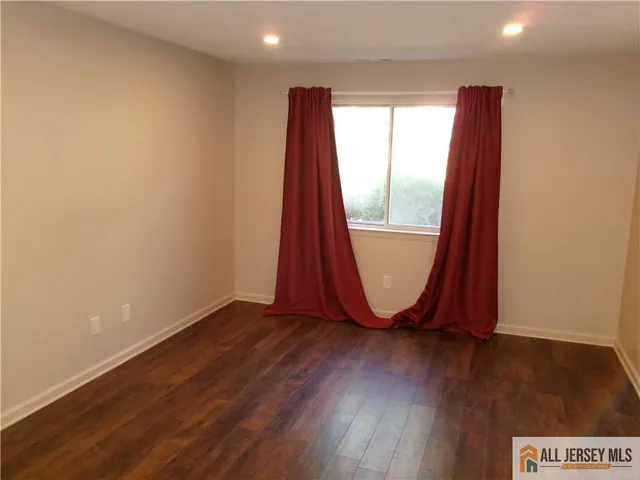 an empty room with wooden floor and a window
