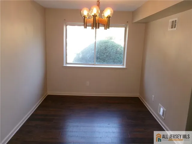a view of a room with wooden floor and a window