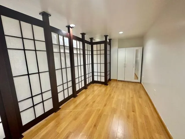 an empty room with wooden floor and windows