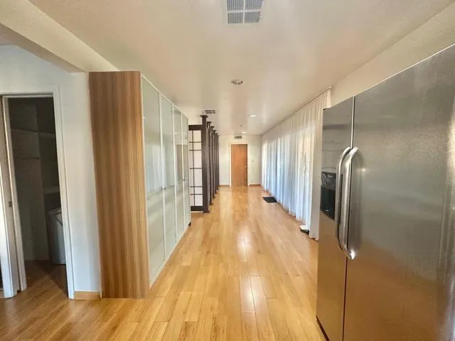 a view of an empty room with wooden floor and stairs