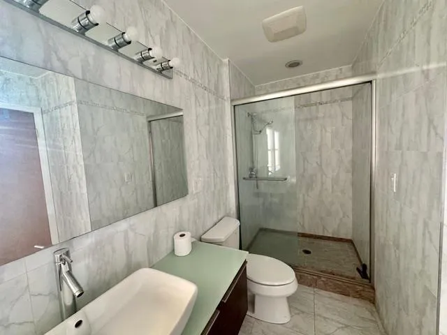 a spacious bathroom with a tub sink and mirror