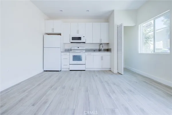 a kitchen with wooden floors and white appliances