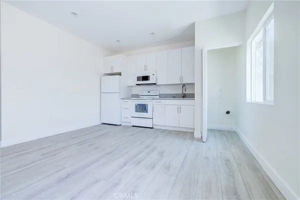 a view of kitchen with wooden floor electronic appliances and window