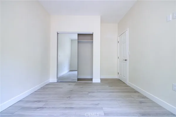 an empty room with wooden floor and entrance