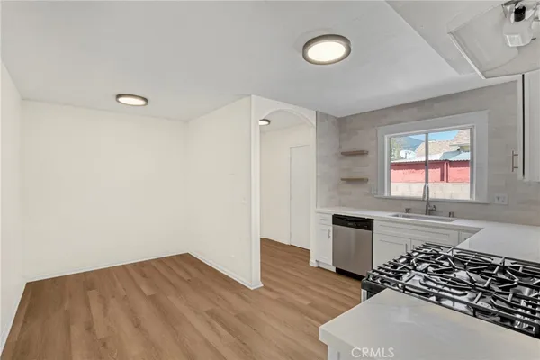a kitchen with granite countertop a stove and wooden floor