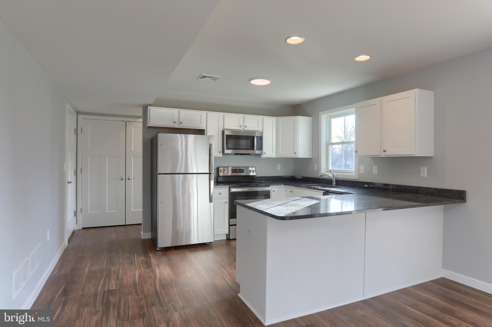 176 Lamp Post Lane Hershey, PA 17033 - Photo 13 of 33 a kitchen with stainless steel appliances granite countertop a refrigerator a sink dishwasher a stove and white countertops with wooden floor