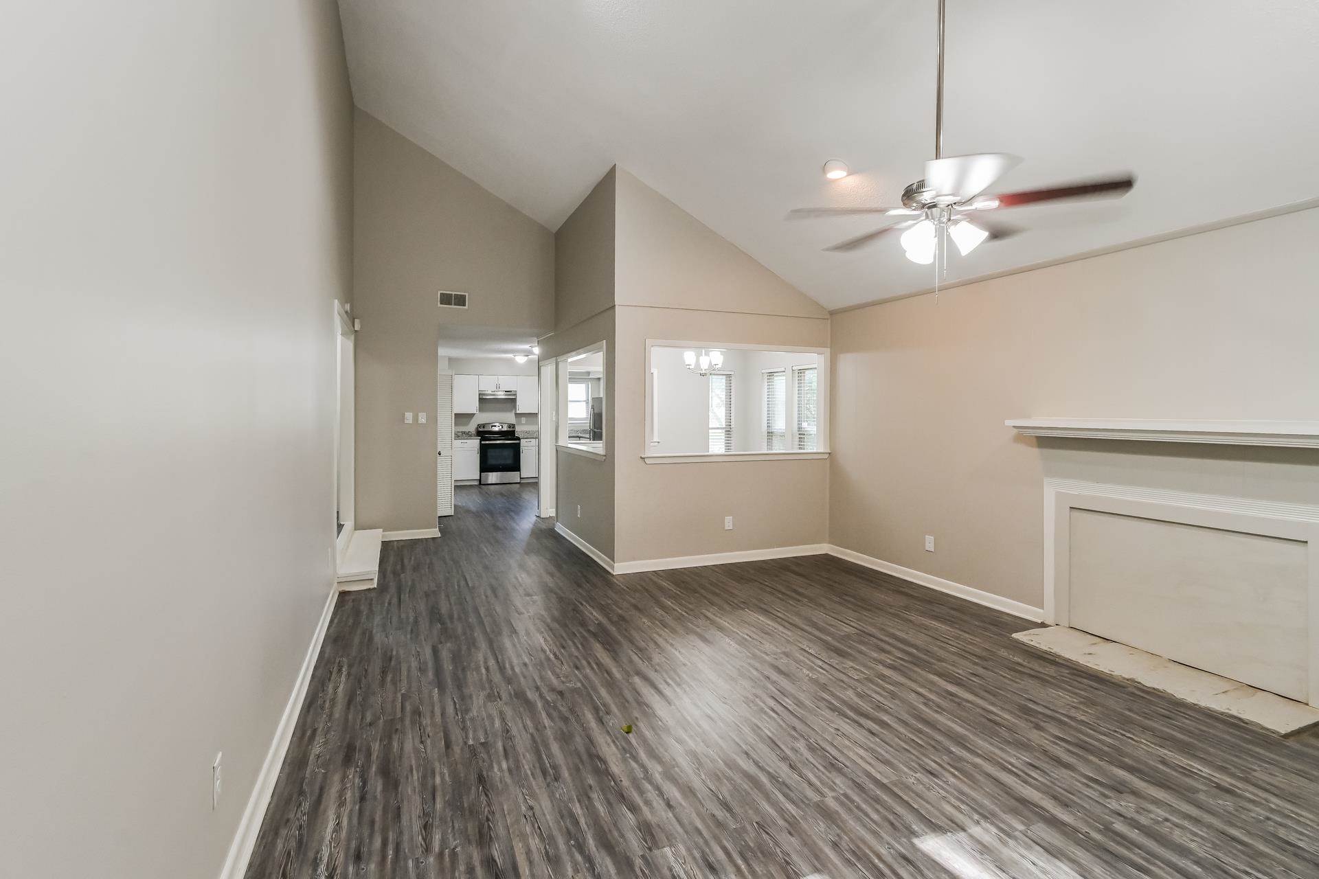 2572 Lynnfield Road Memphis, TN 38119 - Photo 4 of 21 Unfurnished living room featuring ceiling fan, high vaulted ceiling, and dark wood-type flooring