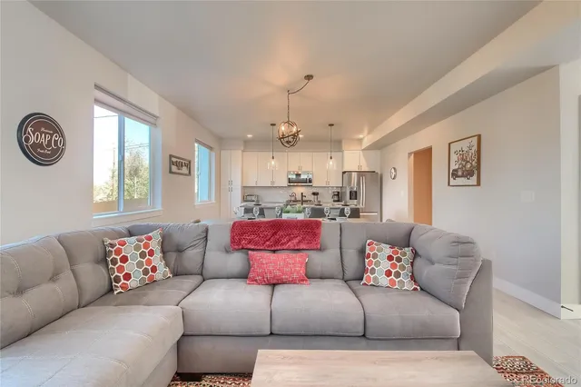 a living room with furniture and kitchen