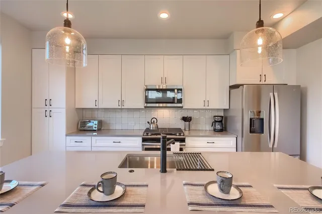 a kitchen with stainless steel appliances a sink stove and refrigerator