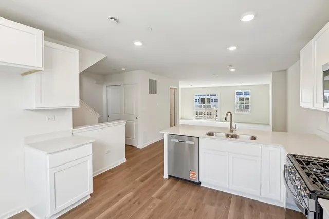 a kitchen with white cabinets sink and stainless steel appliances