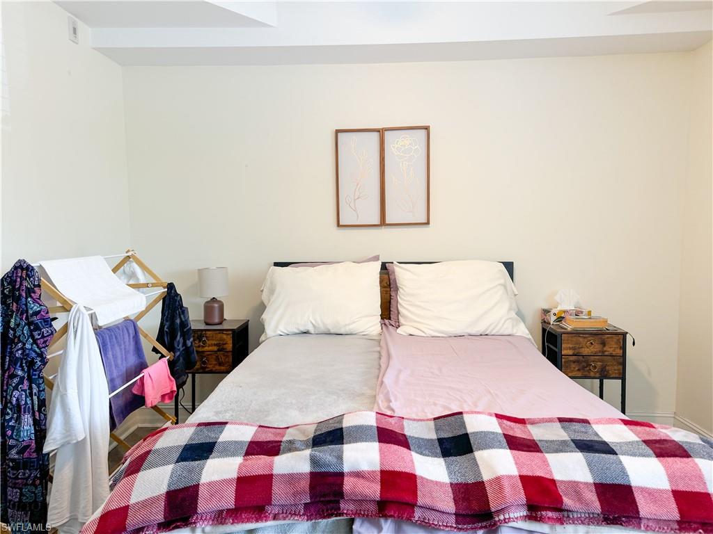1100 Pine Ridge Road, Unit 201B Naples, FL 34108 - Photo 13 of 18 a bedroom with a bed and a lamp