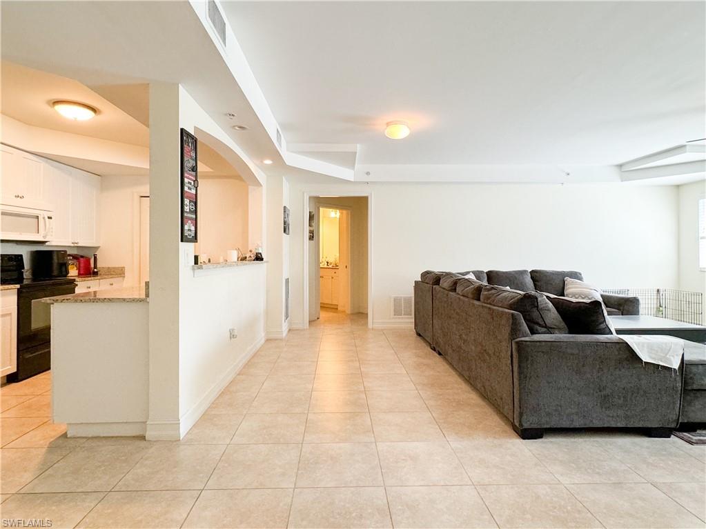 1100 Pine Ridge Road, Unit 201B Naples, FL 34108 - Photo 4 of 18 a living room with furniture and kitchen view